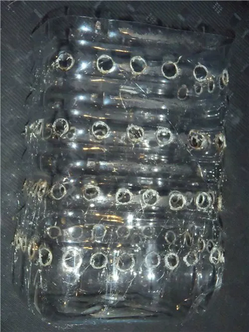 Đục các lỗ tròn nhỏ so le quanh thân chai nhựa để làm nơi trồng củ hành