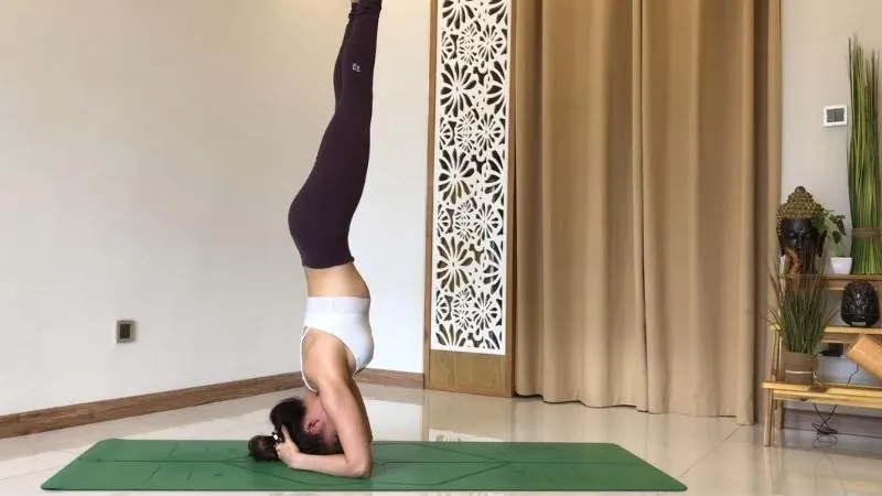 Từ từ nâng hai chân lên cao, duỗi thẳng chân và bàn chân, dồn trọng lực vào vai