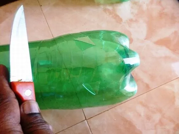 Hình ảnh chai nhựa đã được cắt cổ và khoét lỗ xung quanh thân chai để trồng hành